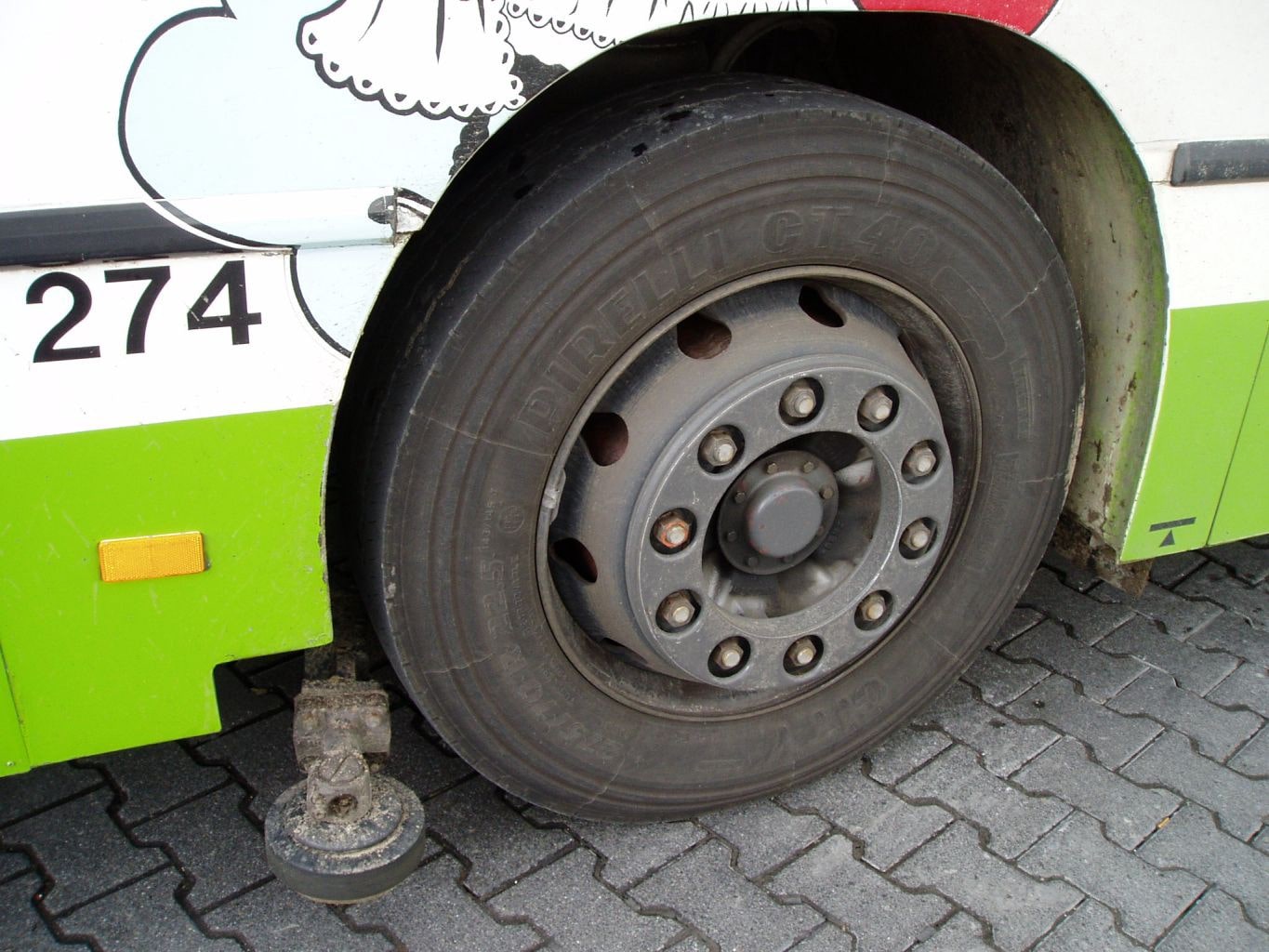 imagem do detalhe de um pneu de ônibus sobre pavimentação