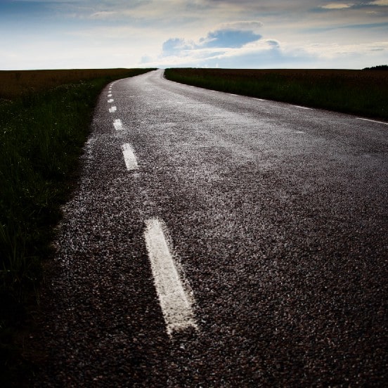 imagem de uma estrada vazia e bem pavimentada sob um claro céu
